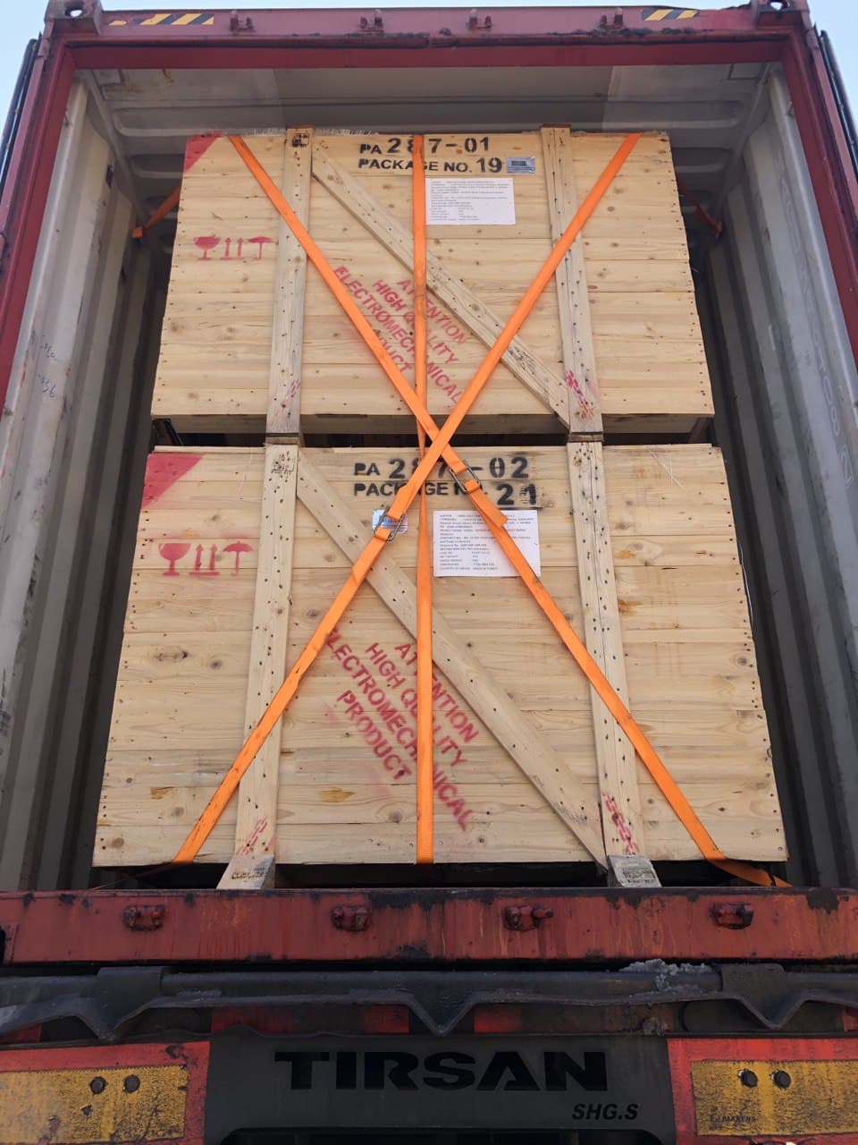 Kiện gỗ được cố định bằng đai trong container.